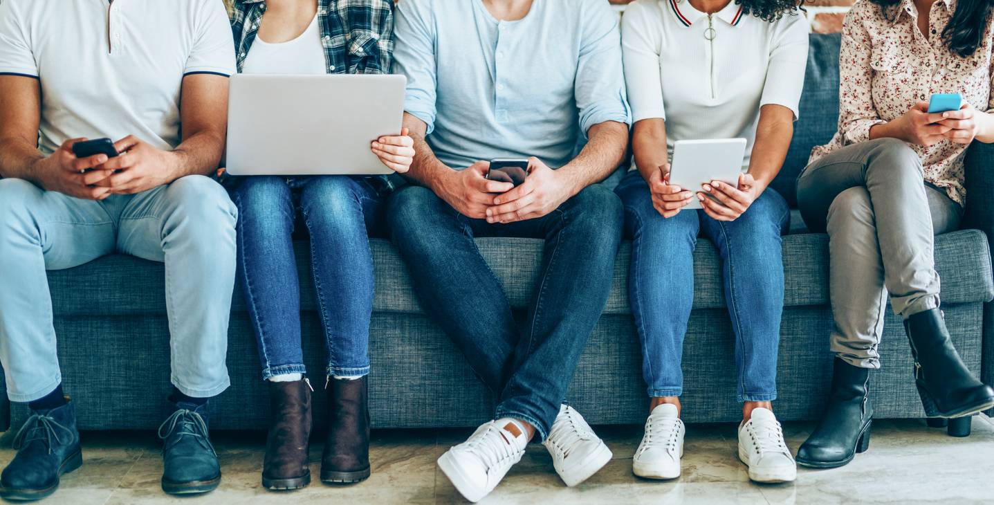 row of people on electronic devices